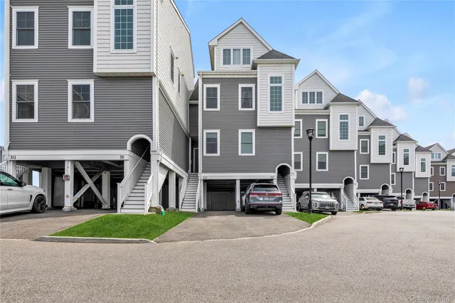 a front view of a house with a garden and parking