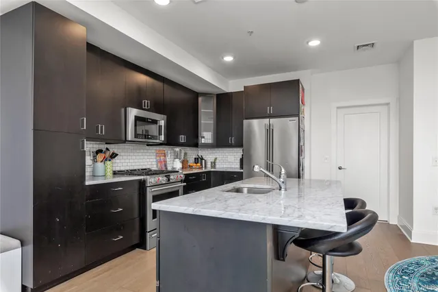 a kitchen with granite countertop a sink stainless steel appliances and cabinets