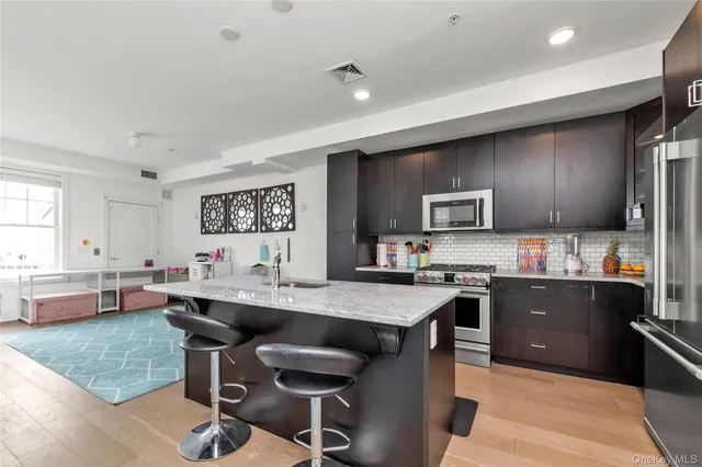 a kitchen with stainless steel appliances kitchen island granite countertop a sink and cabinets