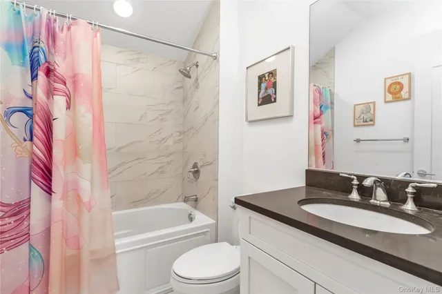 a spacious bathroom with a bathtub sink mirror and toilet