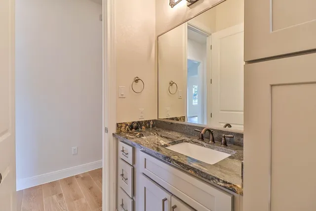 a bathroom with a granite countertop sink and a mirror