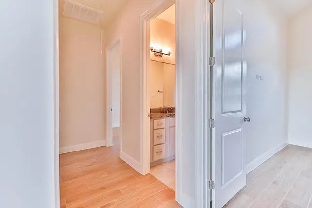 a view of a hallway with wooden floor