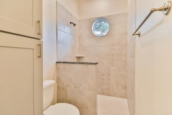 a bathroom with a toilet and a shower