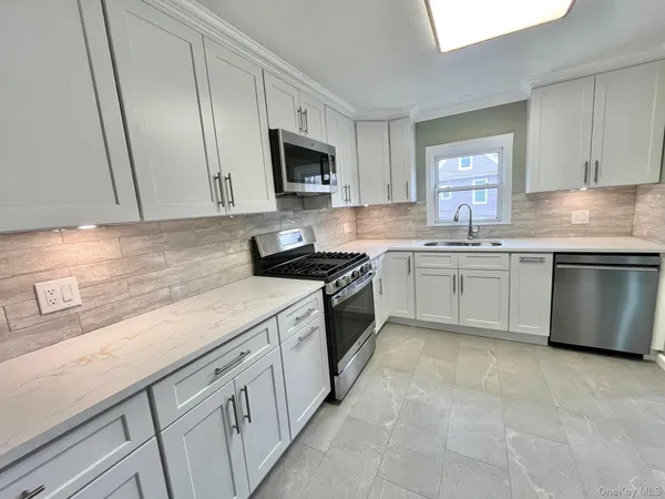 a kitchen with white cabinets stainless steel appliances and sink