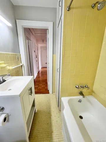 a bathroom with a tub a sink and a mirror