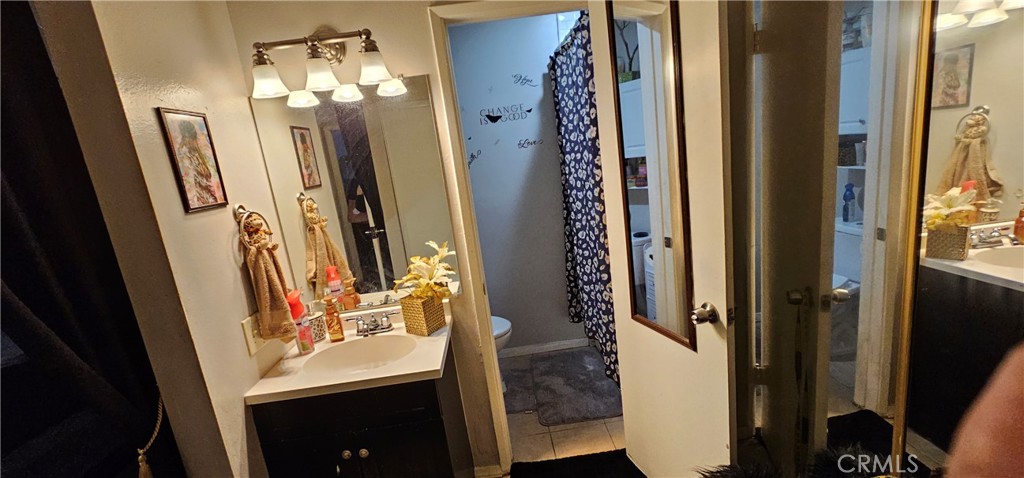5535 Ackerfield Avenue, Unit 9 Long Beach, CA 90805 - Photo 16 of 19 a bathroom with a mirror sink and shower
