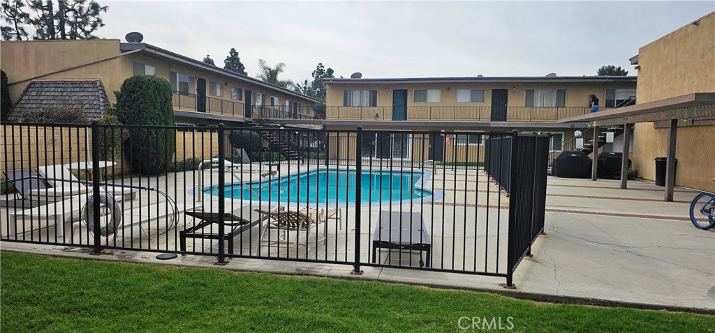 5535 Ackerfield Avenue, Unit 9 Long Beach, CA 90805 - Photo 18 of 19 a view of a brick house with a small yard and a wooden fence