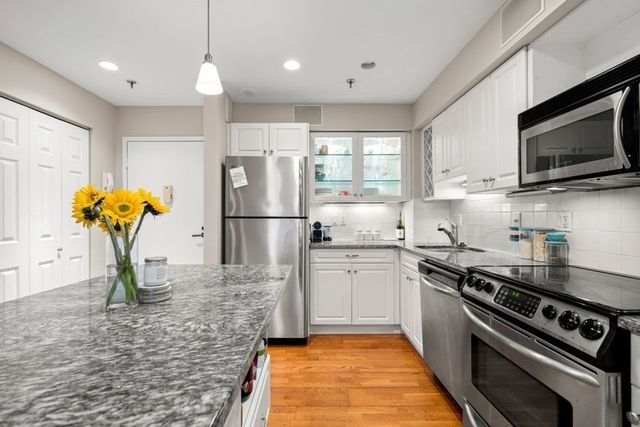 a kitchen with stainless steel appliances granite countertop a sink a stove a microwave and cabinets