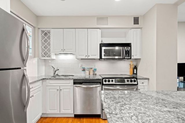 a kitchen with stainless steel appliances granite countertop a refrigerator sink and microwave