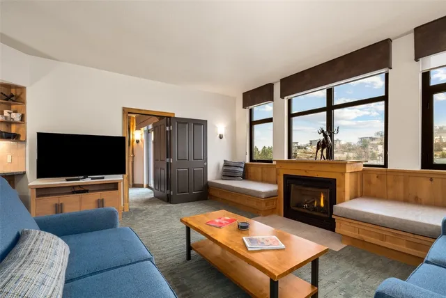 a living room with furniture a flat screen tv and a fireplace