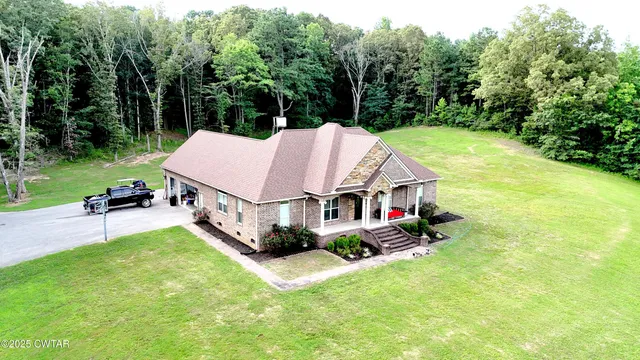 an aerial view of a house with swimming pool and big yard