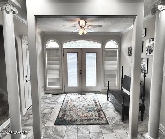 a view of a hallway with windows and chandelier
