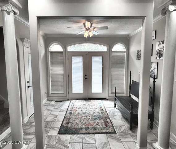 a view of a hallway with windows and chandelier