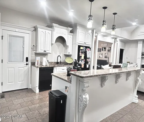 a kitchen with stainless steel appliances granite countertop a sink a stove and a refrigerator