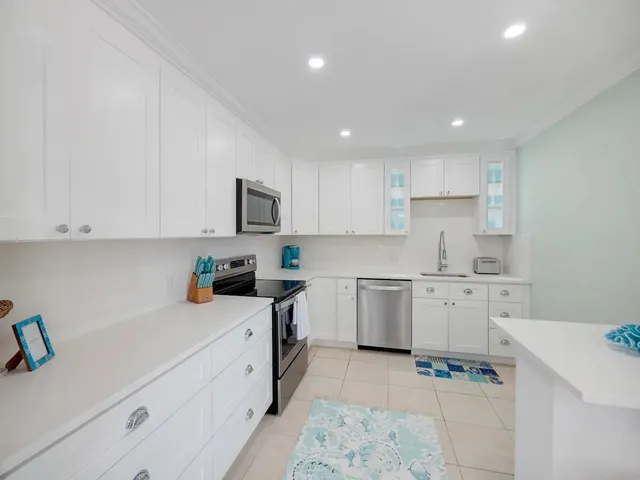 a kitchen with stainless steel appliances kitchen island granite countertop a refrigerator and cabinets