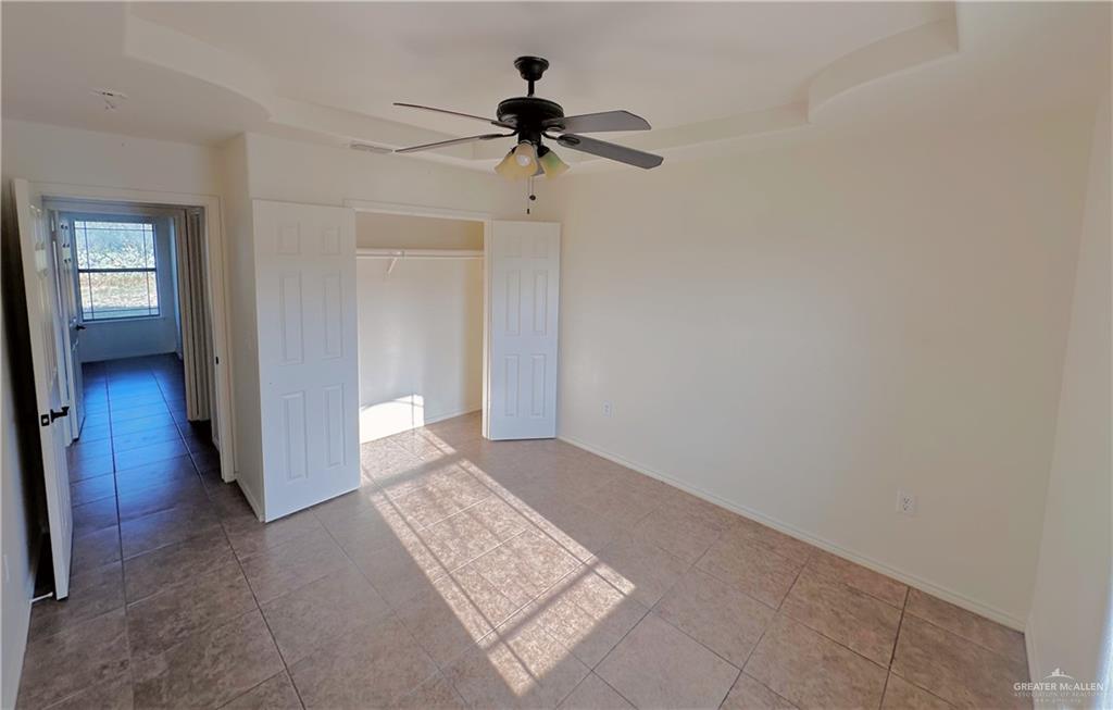 311 Teodora Drive Rio Grande City, TX 78582 - Photo 7 of 15 Unfurnished bedroom with a closet, tile patterned flooring, and a ceiling fan