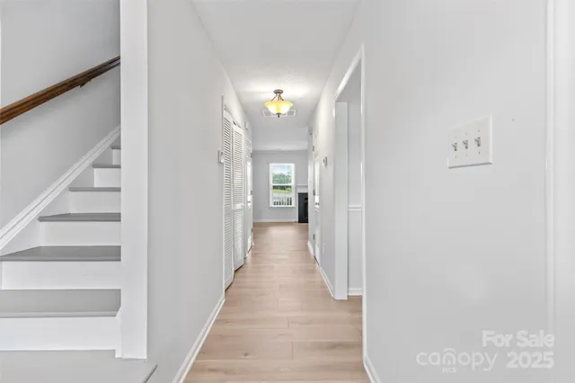 a view of a hallway with wooden floor and staircase