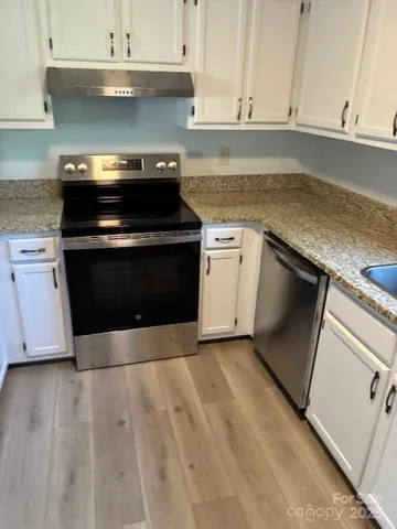 a kitchen with granite countertop a stove and a sink