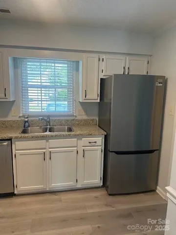 a kitchen with granite countertop a refrigerator and a sink