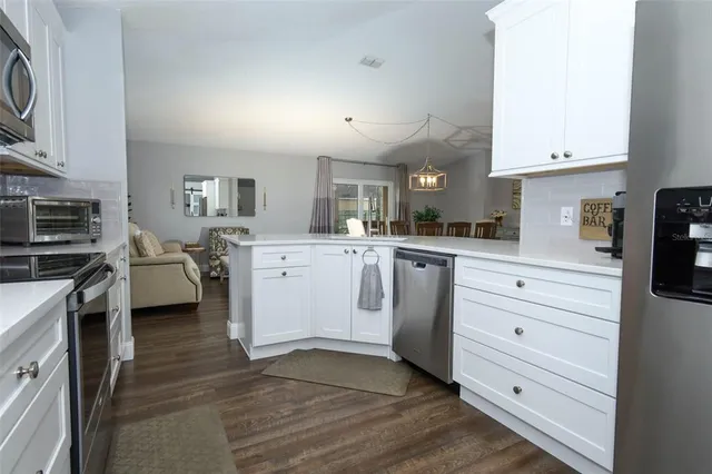 a kitchen with white cabinets and white appliances
