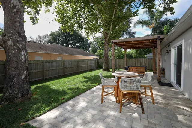 a view of backyard with table and chairs and a large tree