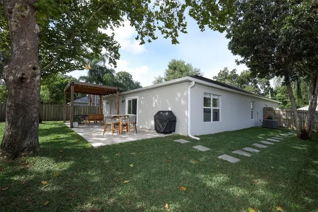 a view of a house with backyard and sitting area
