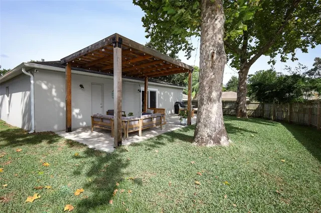a view of a house with backyard and sitting area
