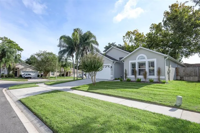 a front view of a house with a yard and trees