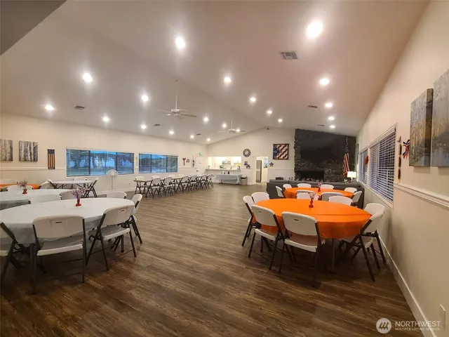 a room with wooden floor table tennis pool table and chairs