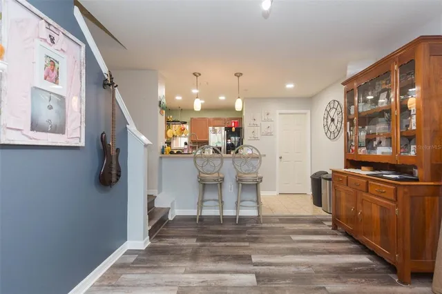 a kitchen with stainless steel appliances granite countertop a refrigerator and a stove top oven with wooden floor