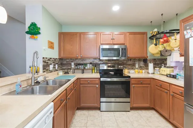 a kitchen with stainless steel appliances a stove sink microwave and cabinets