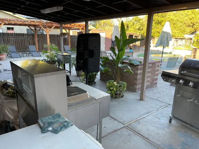 a view of a patio with table and chairs potted plants and palm tree
