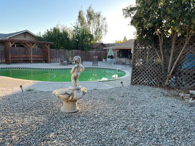 a view of a backyard with a small pool and sitting area