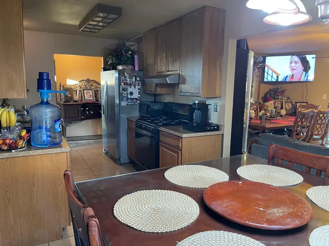 a kitchen with stainless steel appliances a dining table and chairs