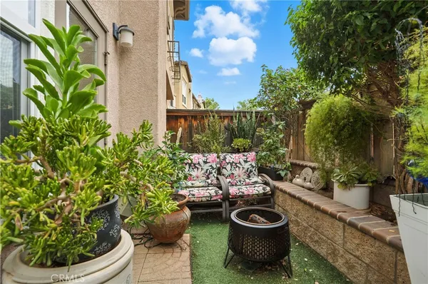 a view of a patio with couches table and chairs and potted plants