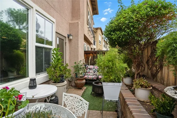 a view of a chair and table in backyard with plants