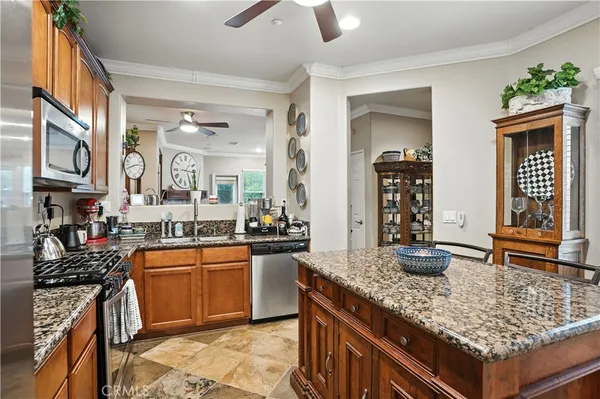 a kitchen with stainless steel appliances granite countertop a sink and a refrigerator