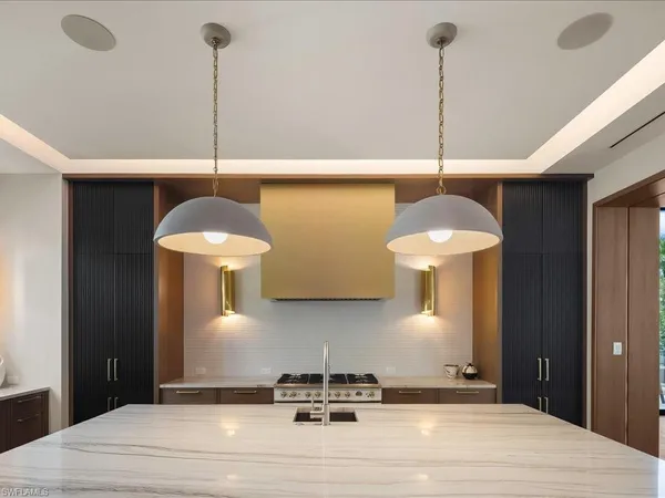 a kitchen with stainless steel appliances granite countertop a stove a sink and a wooden floor