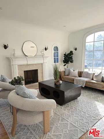 a living room with furniture fireplace and a large window