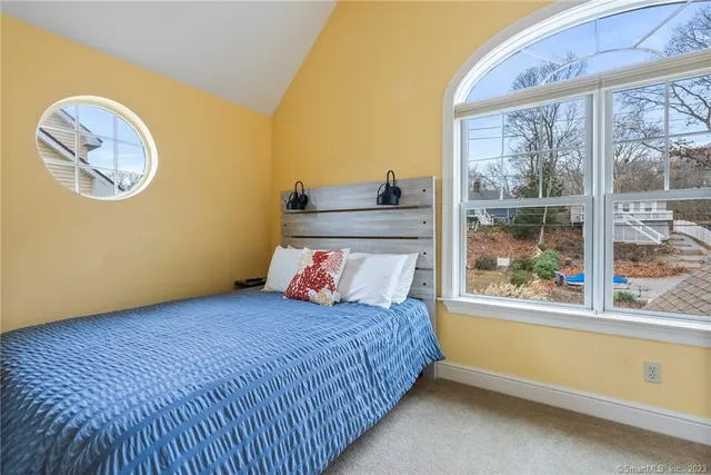 a bedroom with a bed and painting on the wall