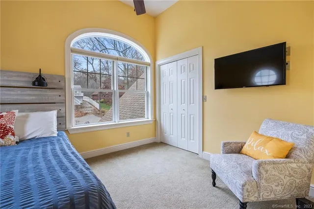 a bedroom with a bed and a couch next to a window