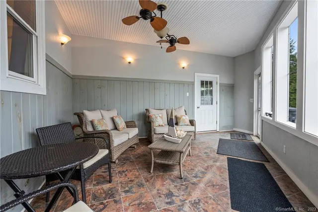 a view of a back yard with flower plants and large tree