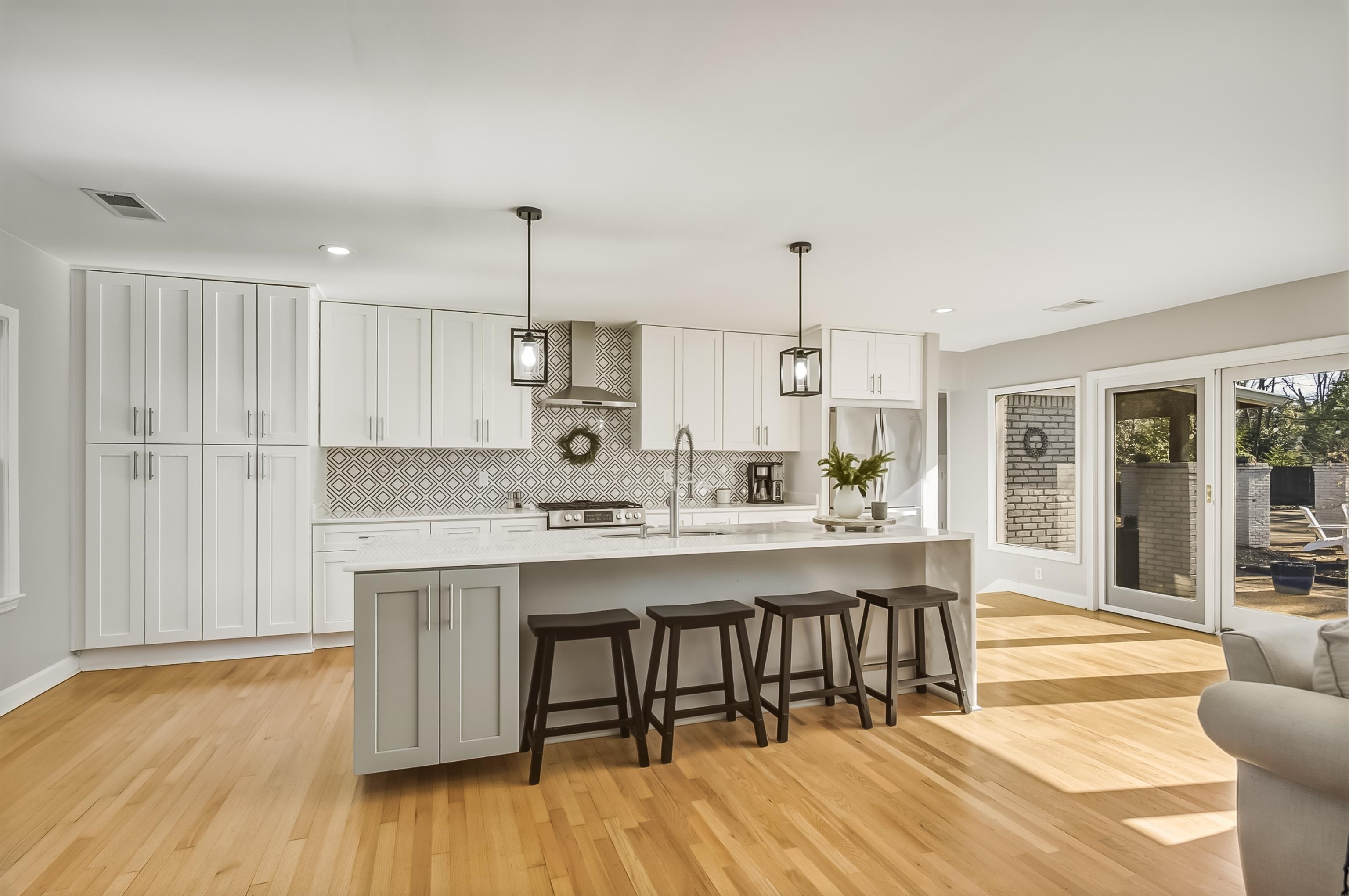 5155 Shady Grove Road Memphis, TN 38117 - Photo 12 of 40 Kitchen featuring a kitchen breakfast bar, hanging light fixtures, white cabinetry, a spacious island, and light wood-type flooring