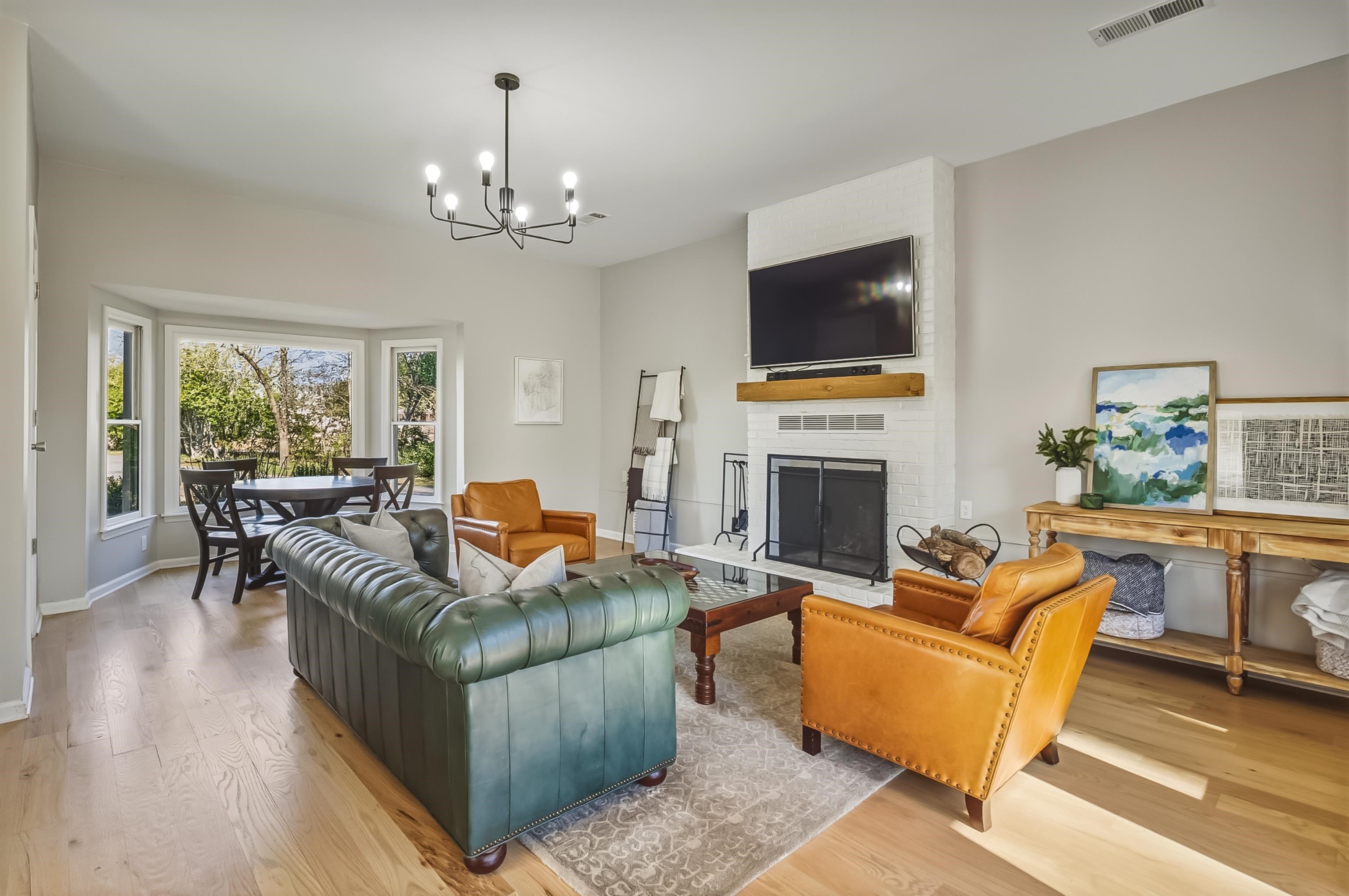5155 Shady Grove Road Memphis, TN 38117 - Photo 15 of 40 Living area with light wood-type flooring, a brick fireplace, and a chandelier