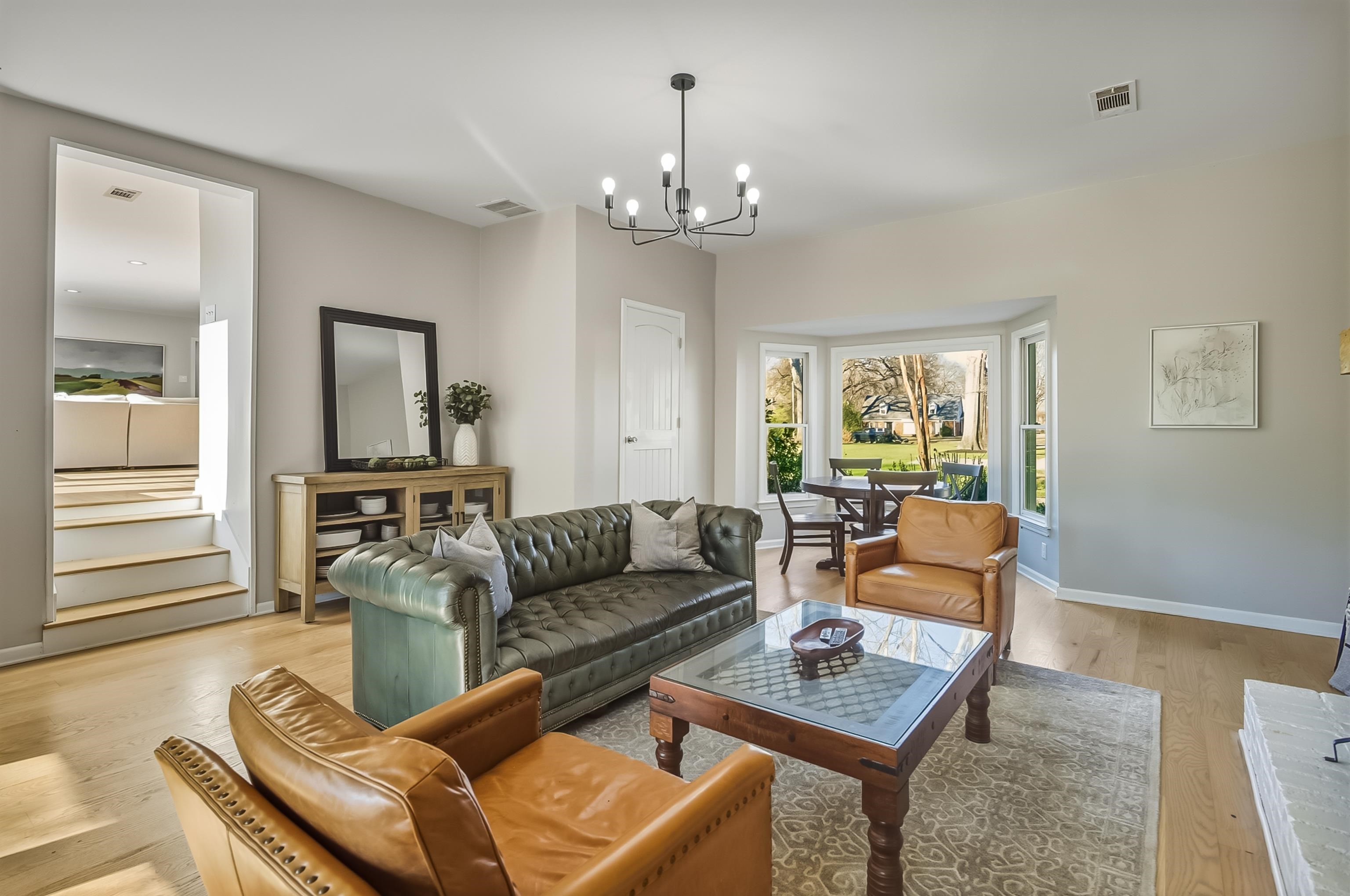 5155 Shady Grove Road Memphis, TN 38117 - Photo 16 of 40 Living area featuring light wood-style floors, stairs, and a chandelier