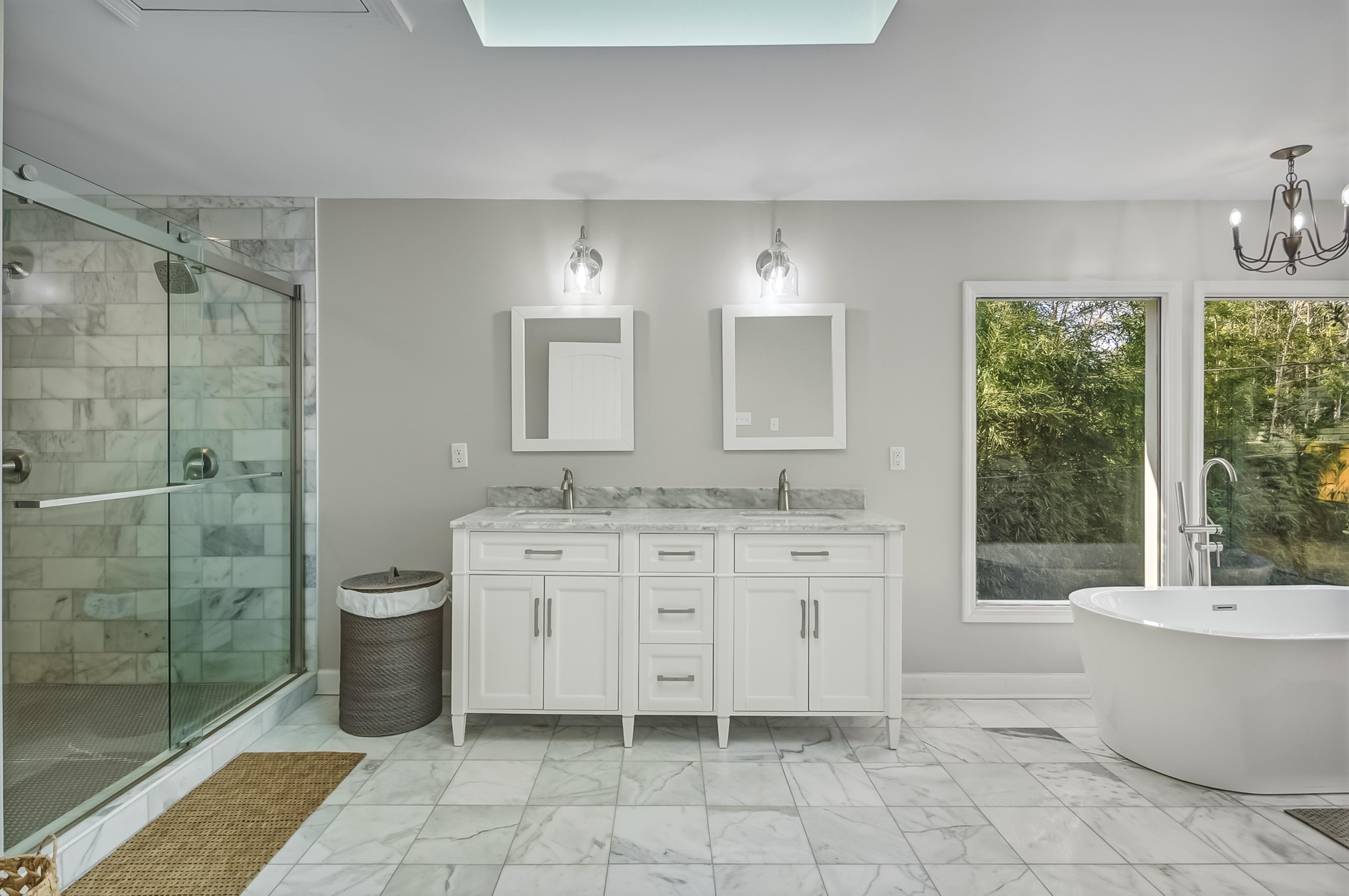5155 Shady Grove Road Memphis, TN 38117 - Photo 22 of 40 Full bath with double vanity, light marble finish flooring, a stall shower, a soaking tub, and a chandelier