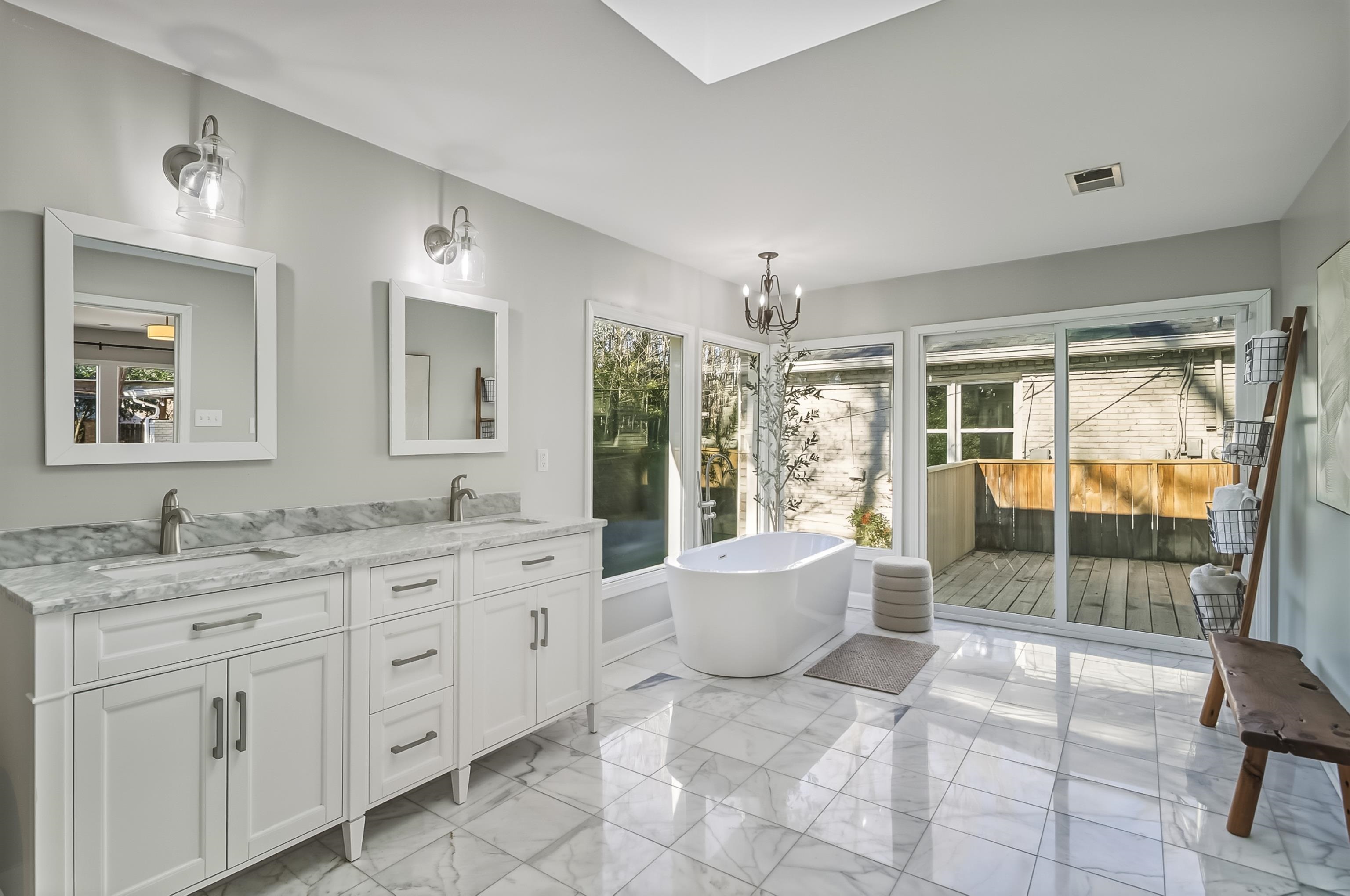 5155 Shady Grove Road Memphis, TN 38117 - Photo 24 of 40 Bathroom with double vanity, a freestanding bath, a skylight, light marble finish flooring, and a chandelier