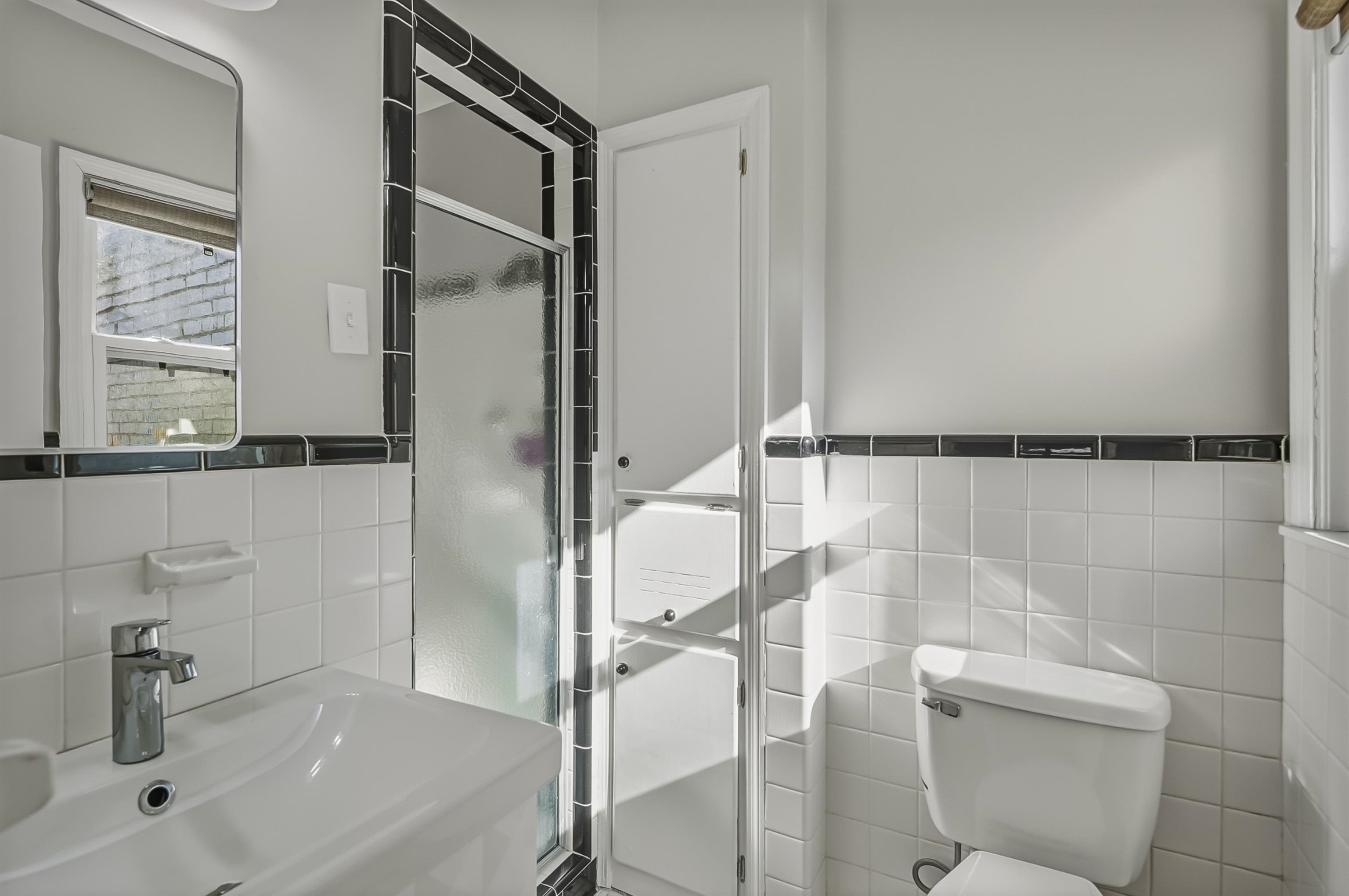 5155 Shady Grove Road Memphis, TN 38117 - Photo 33 of 40 Full bathroom with tile walls, a stall shower, and a wainscoted wall