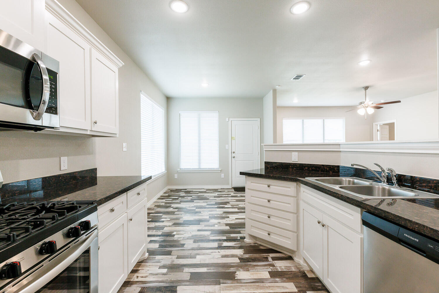 6956 12th Street Lubbock, TX 79416 - Photo 11 of 43 a kitchen with granite countertop a sink and a stove