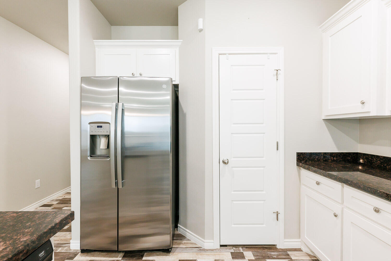 6956 12th Street Lubbock, TX 79416 - Photo 13 of 43 a kitchen with a refrigerator and cabinets